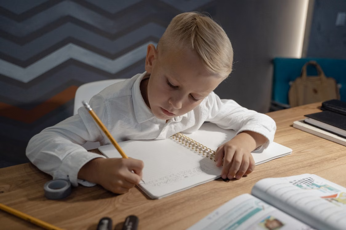 A boy practising handwriting at a desk